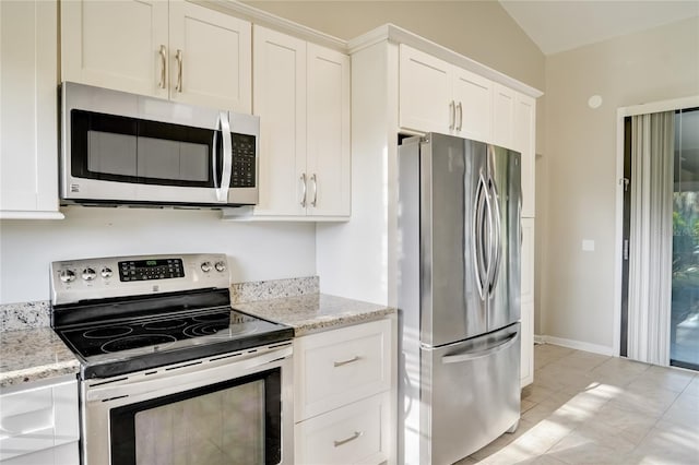 kitchen featuring white cabinetry, stainless steel appliances, light stone countertops, and light tile patterned floors