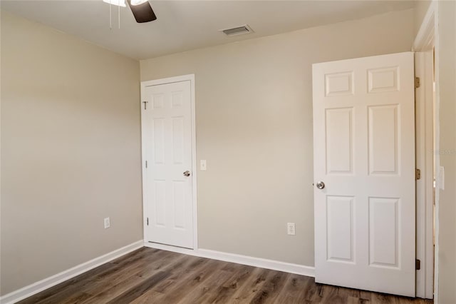 unfurnished bedroom featuring dark wood-type flooring and ceiling fan