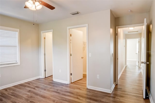 unfurnished bedroom featuring a walk in closet and light hardwood / wood-style flooring