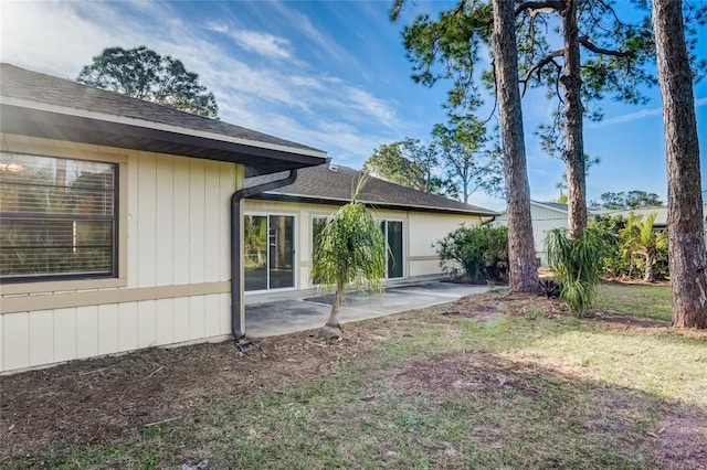 rear view of house featuring a patio and a lawn