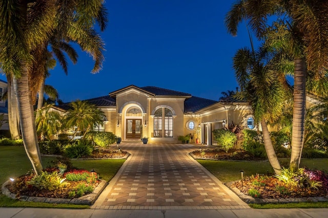 mediterranean / spanish home with a yard and french doors