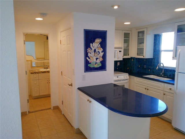 kitchen with white cabinetry, sink, decorative backsplash, kitchen peninsula, and white appliances