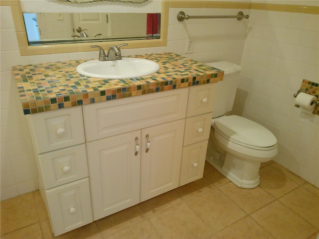 bathroom with vanity, tile walls, tile patterned floors, and toilet