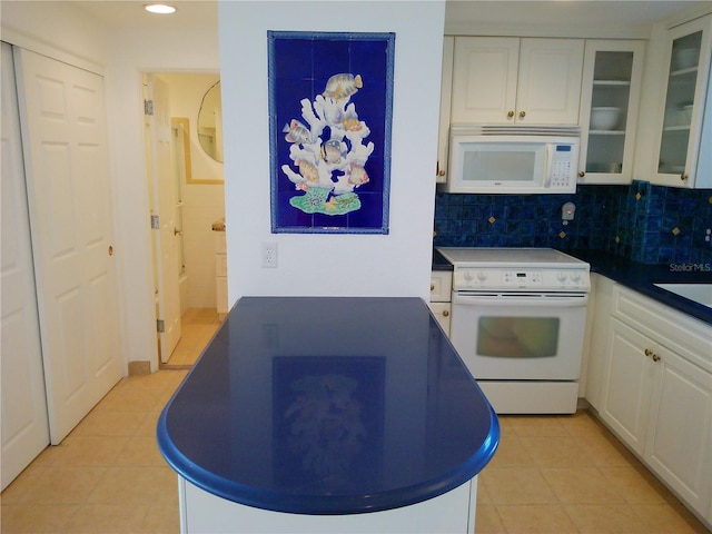 kitchen featuring white cabinetry, light tile patterned floors, white appliances, and decorative backsplash