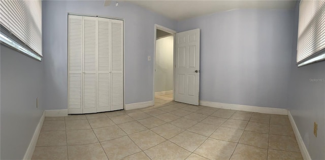 unfurnished bedroom with light tile patterned flooring and a closet