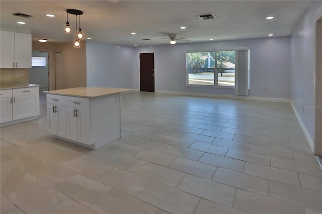 5729 13th St, Zephyrhills, FL 33542 - kitchen with a ceiling fan, open floor plan, recessed lighting, white cabinetry, and light stone counters