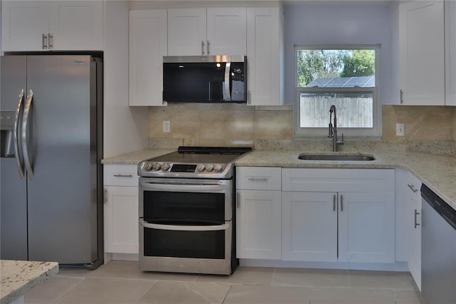 5729 13th St, Zephyrhills, FL 33542 - kitchen with appliances with stainless steel finishes, a sink, white cabinets, and light stone counters