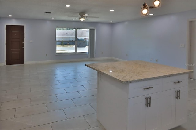 5729 13th St, Zephyrhills, FL 33542 - kitchen with ceiling fan, light stone countertops, a center island, open floor plan, and white cabinetry