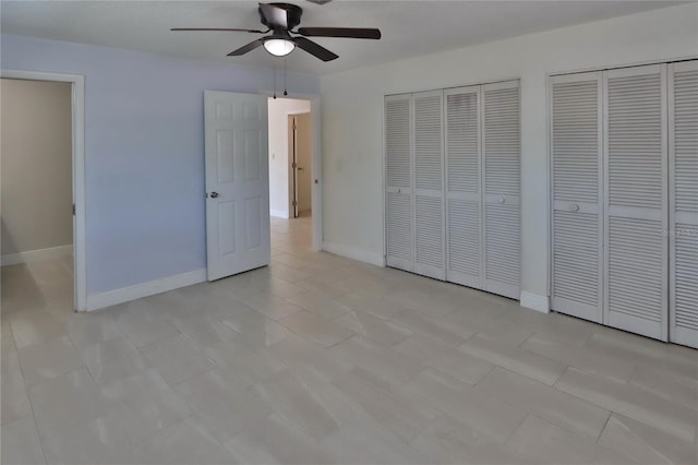 5729 13th St, Zephyrhills, FL 33542 - unfurnished bedroom with multiple closets, baseboards, and ceiling fan