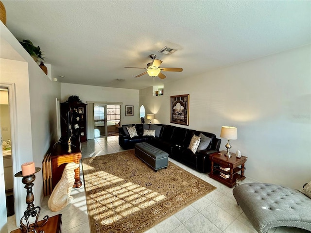 living room featuring ceiling fan, a textured ceiling, and light tile patterned floors