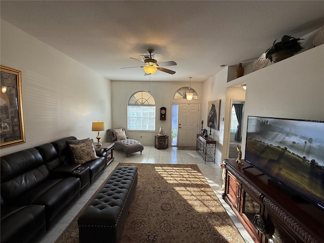 tiled living room with ceiling fan and a textured ceiling