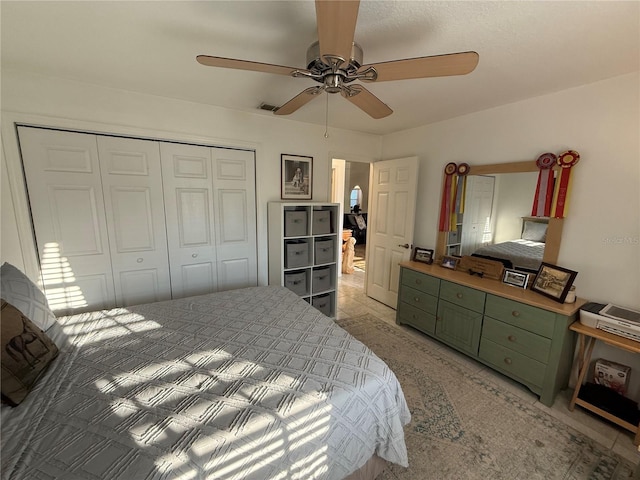 tiled bedroom with ceiling fan and a closet