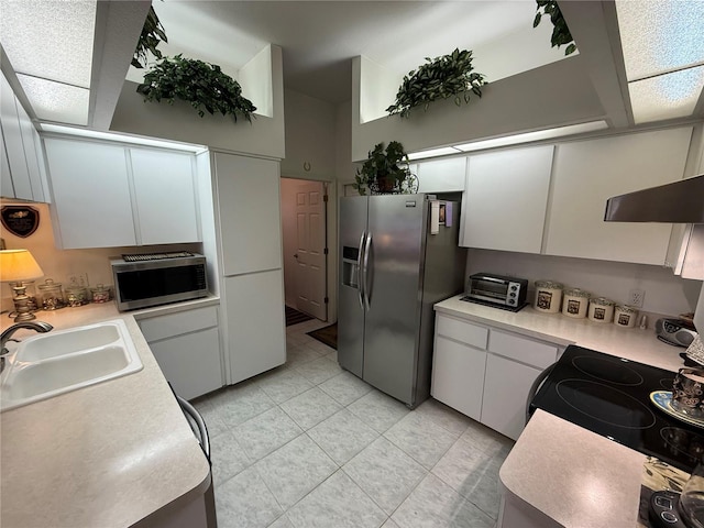 kitchen with light tile patterned floors, stainless steel appliances, sink, and white cabinets