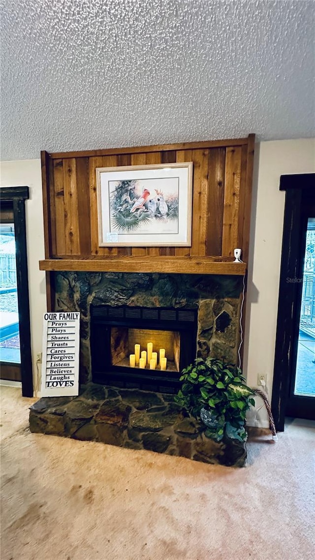 room details featuring carpet, a textured ceiling, and a fireplace