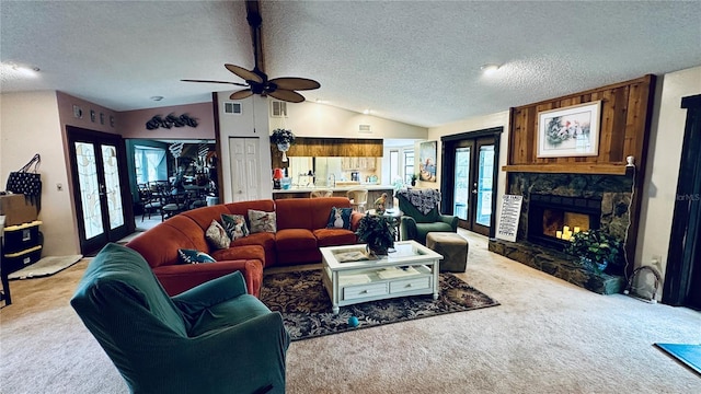 living room with carpet, vaulted ceiling with beams, a stone fireplace, and a textured ceiling