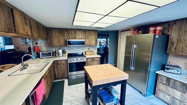 kitchen featuring appliances with stainless steel finishes, sink, and decorative backsplash