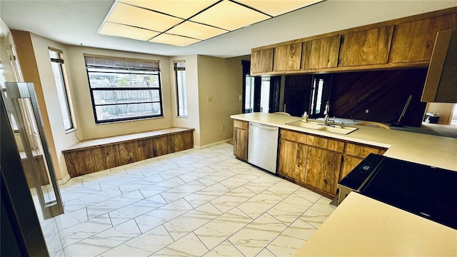 1670 Monterey Dr, Clearwater, FL 33756 - kitchen featuring a sink, stainless steel dishwasher, light marble finish flooring, light countertops, and brown cabinetry