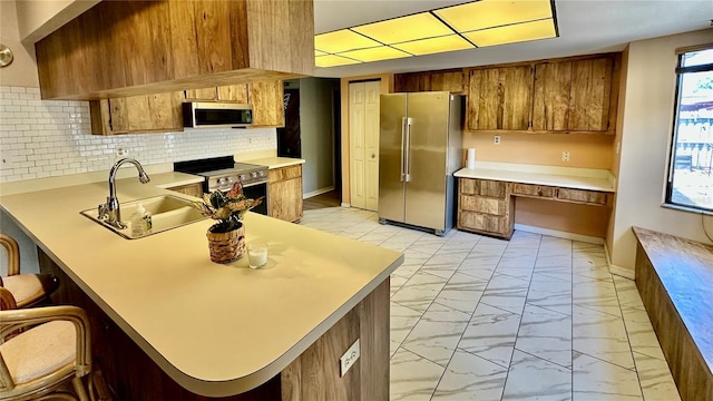 1670 Monterey Dr, Clearwater, FL 33756 - kitchen with stainless steel appliances, light marble finish floors, a sink, and brown cabinets