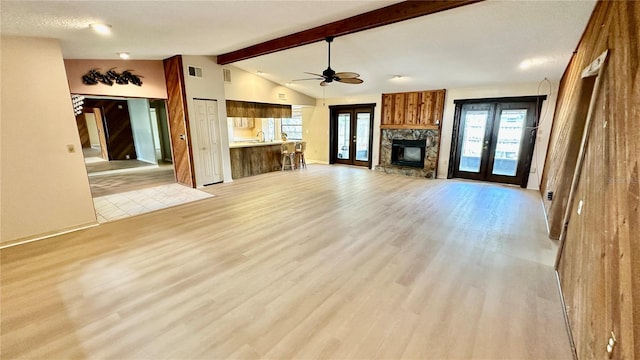1670 Monterey Dr, Clearwater, FL 33756 - unfurnished living room with french doors, a fireplace, light wood-style flooring, and healthy amount of natural light