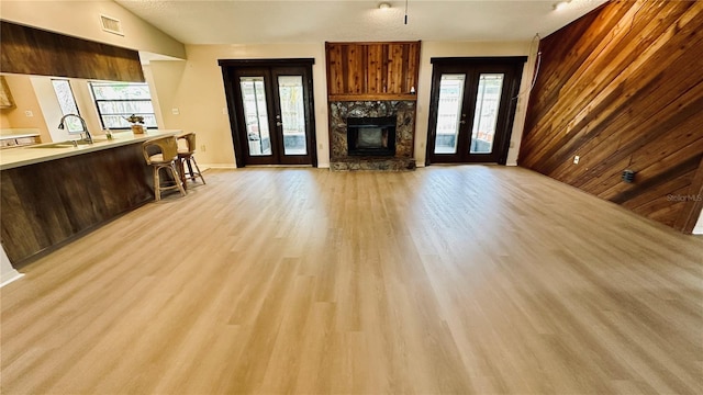 1670 Monterey Dr, Clearwater, FL 33756 - living area featuring french doors, light wood-style floors, a fireplace, and plenty of natural light