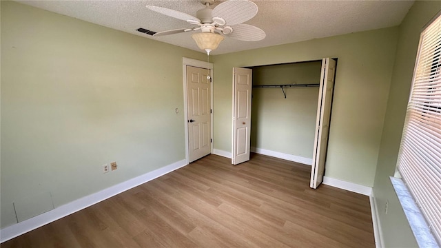 1670 Monterey Dr, Clearwater, FL 33756 - unfurnished bedroom featuring wood finished floors, baseboards, a closet, a textured ceiling, and ceiling fan