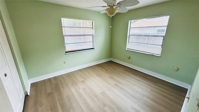 1670 Monterey Dr, Clearwater, FL 33756 - spare room featuring plenty of natural light, wood finished floors, a ceiling fan, baseboards, and a textured ceiling