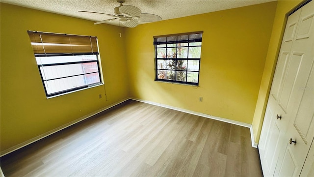 1670 Monterey Dr, Clearwater, FL 33756 - unfurnished bedroom with a textured ceiling, wood finished floors, baseboards, and a ceiling fan