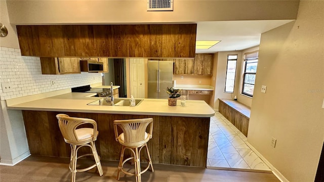 1670 Monterey Dr, Clearwater, FL 33756 - kitchen featuring appliances with stainless steel finishes, light countertops, light marble finish flooring, and a peninsula