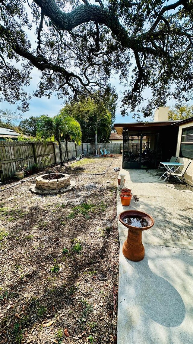 1670 Monterey Dr, Clearwater, FL 33756 - fenced backyard featuring an outdoor fire pit, a patio, and a sunroom