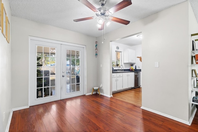 interior space featuring sink, hardwood / wood-style flooring, french doors, and a textured ceiling