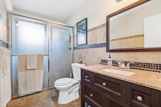 bathroom featuring tile walls, vanity, a shower with shower door, tile patterned floors, and toilet