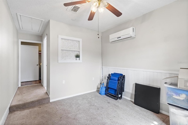 interior space featuring ceiling fan, a wall mounted air conditioner, and a textured ceiling