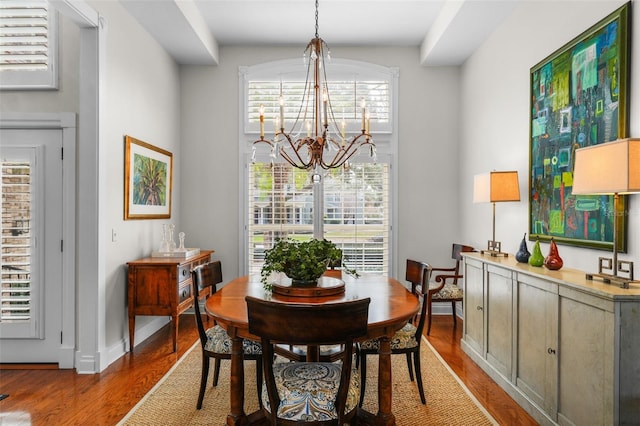 dining area with hardwood / wood-style floors and a chandelier