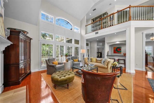 living room featuring high vaulted ceiling and hardwood / wood-style floors