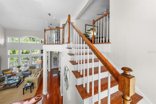 stairway featuring hardwood / wood-style flooring and a high ceiling