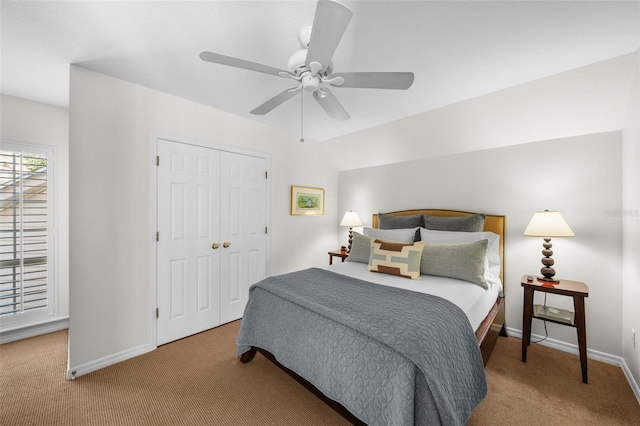 carpeted bedroom with ceiling fan and a closet