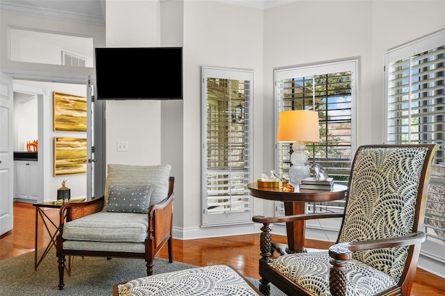 living area featuring ornamental molding and hardwood / wood-style floors