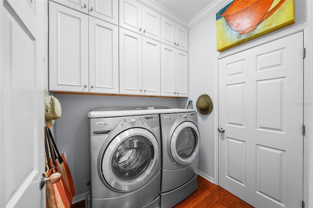 laundry area featuring cabinets, ornamental molding, dark hardwood / wood-style floors, and washing machine and clothes dryer