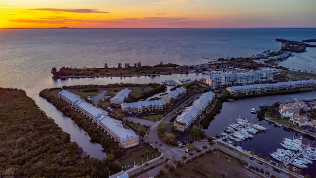 aerial view at dusk featuring a water view