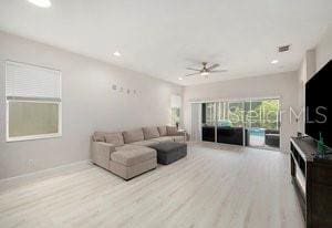 living room featuring ceiling fan and light hardwood / wood-style floors