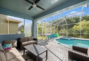 view of swimming pool featuring an in ground hot tub, an outdoor hangout area, glass enclosure, and a patio