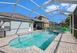 view of swimming pool with an in ground hot tub, a patio area, and glass enclosure