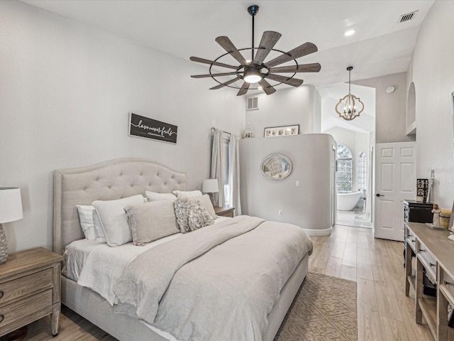 bedroom with light wood-type flooring, an inviting chandelier, visible vents, and high vaulted ceiling