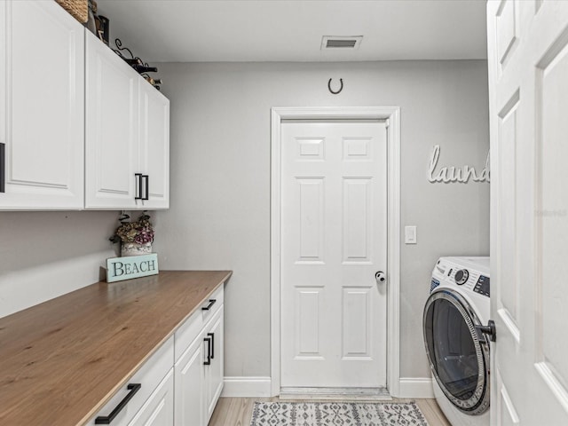 laundry area with washer / clothes dryer, cabinet space, visible vents, and baseboards