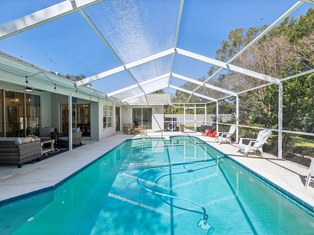 view of swimming pool with glass enclosure, a patio, an outdoor hangout area, a ceiling fan, and a fenced in pool