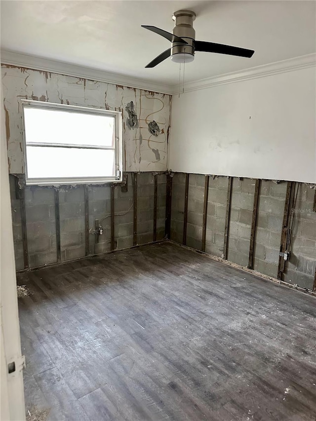 basement with ceiling fan, ornamental molding, and dark hardwood / wood-style flooring