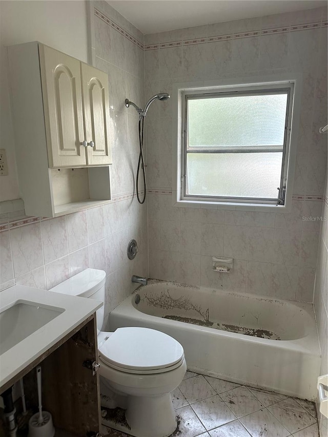 full bathroom with toilet, tiled shower / bath, tile walls, vanity, and decorative backsplash