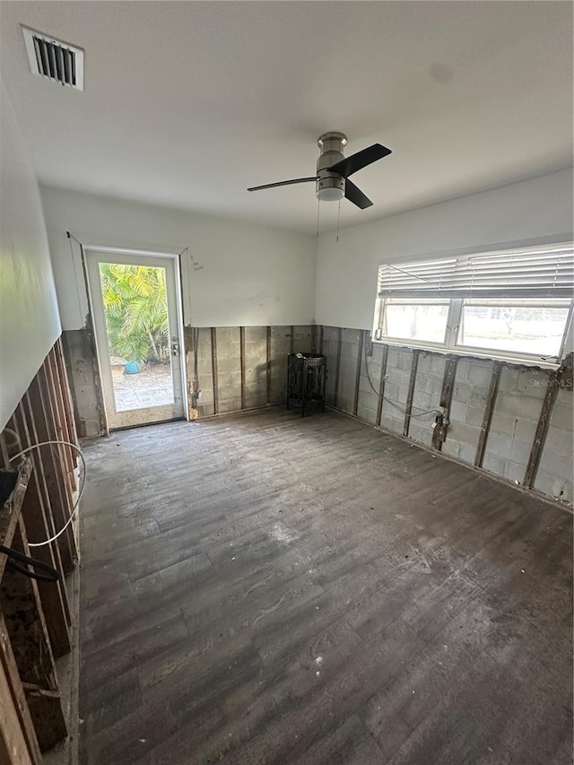 unfurnished room featuring dark hardwood / wood-style floors, a wealth of natural light, and ceiling fan