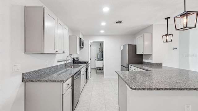 kitchen with pendant lighting, stainless steel appliances, kitchen peninsula, and sink