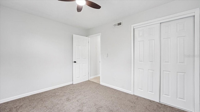 unfurnished bedroom with a closet, ceiling fan, and carpet flooring